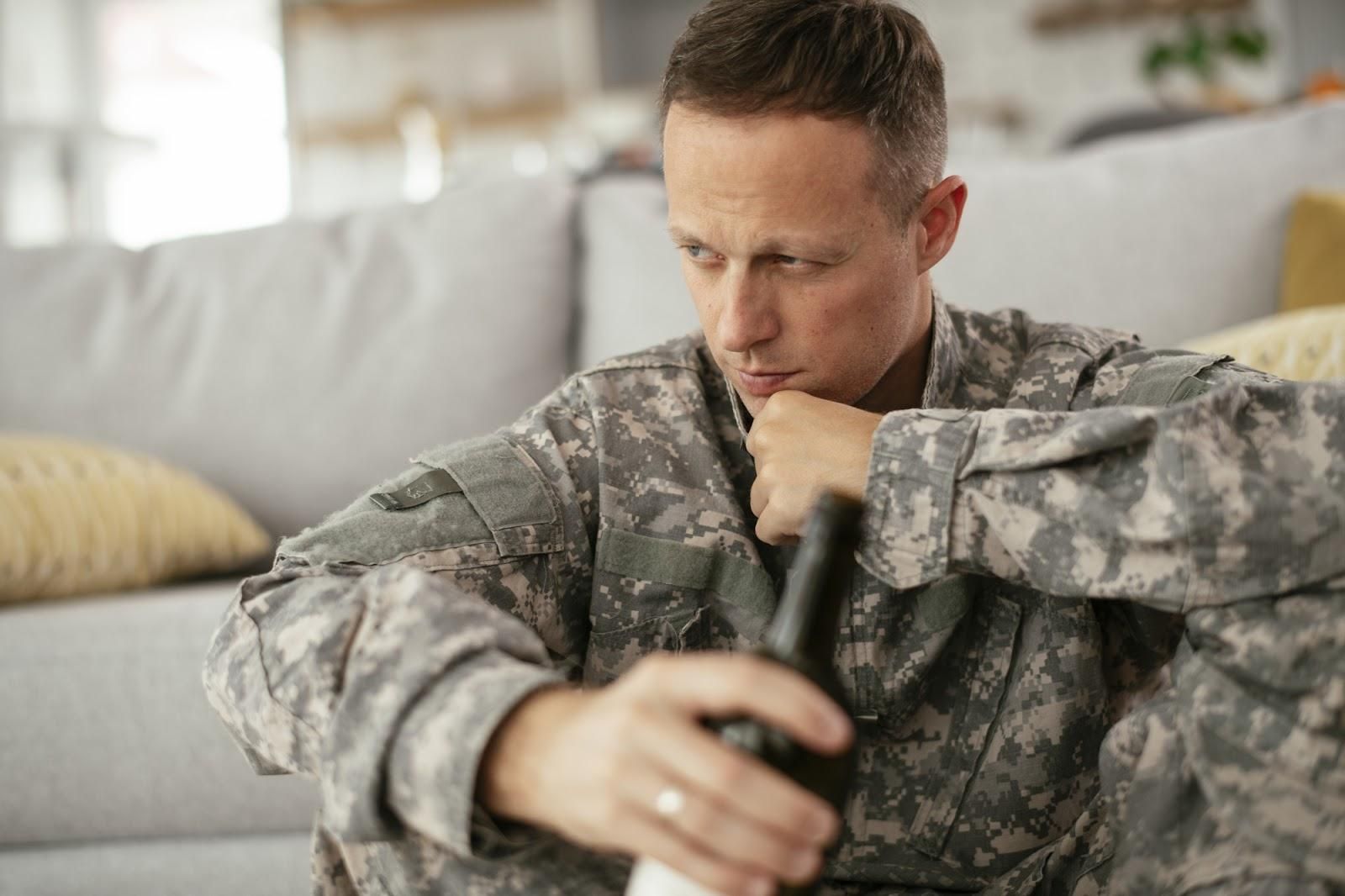 Soldier drinking beer at home, gazing into the distance; concept for DUI in the military.