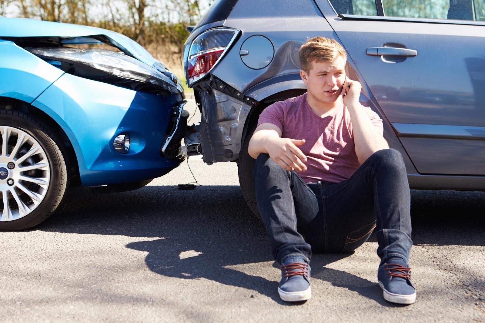 A teenage driver makes a phone call after a collision with another vehicle.