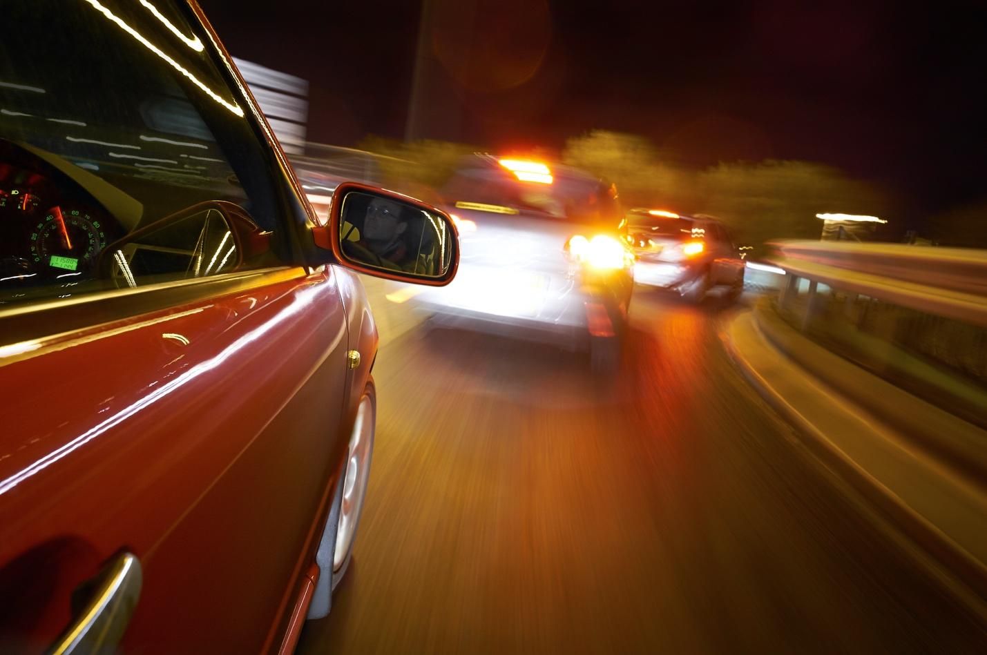 Speeding vehicles at night; streaking headlights.