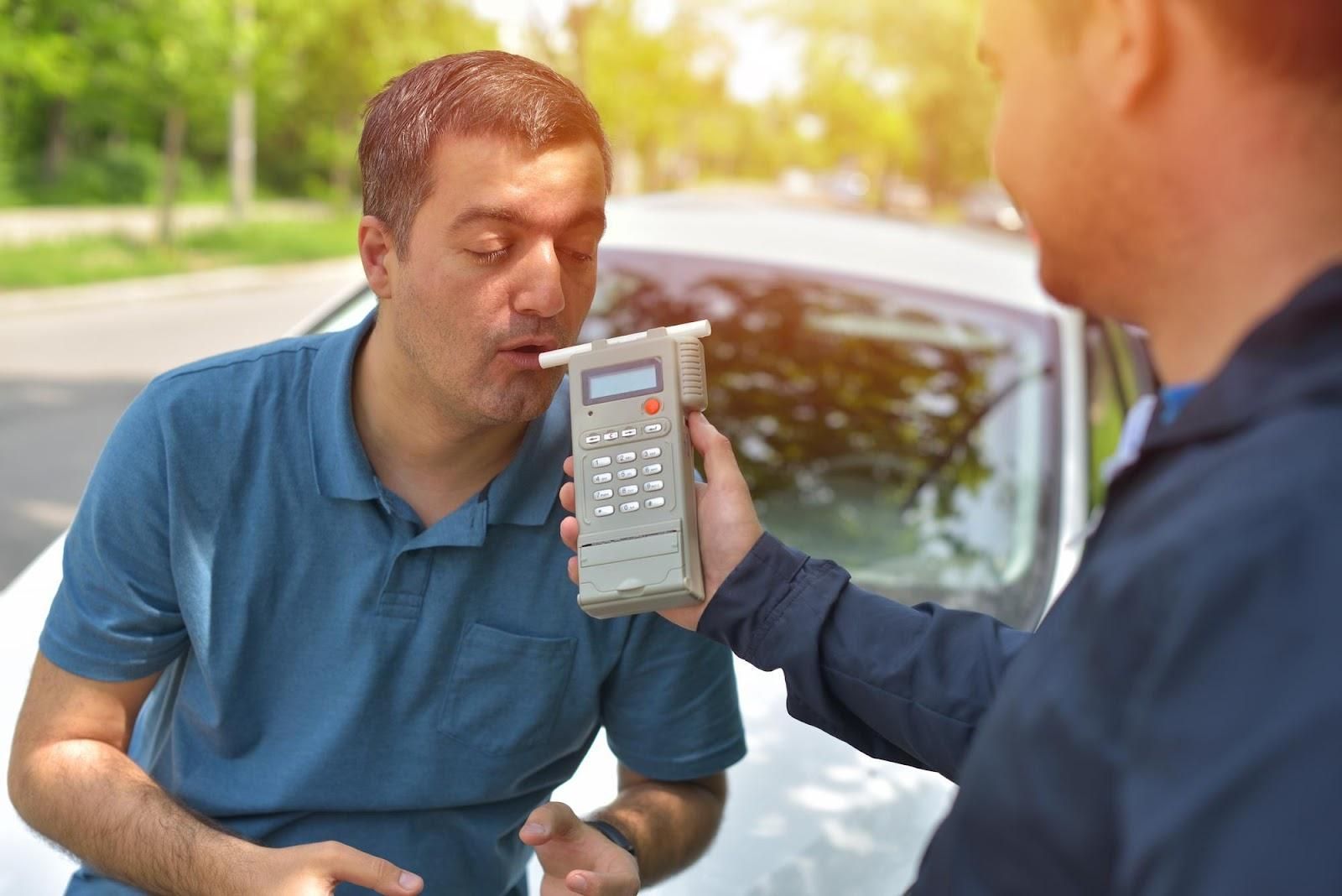 Image of suspect taking breathalyzer test; DUI concept.