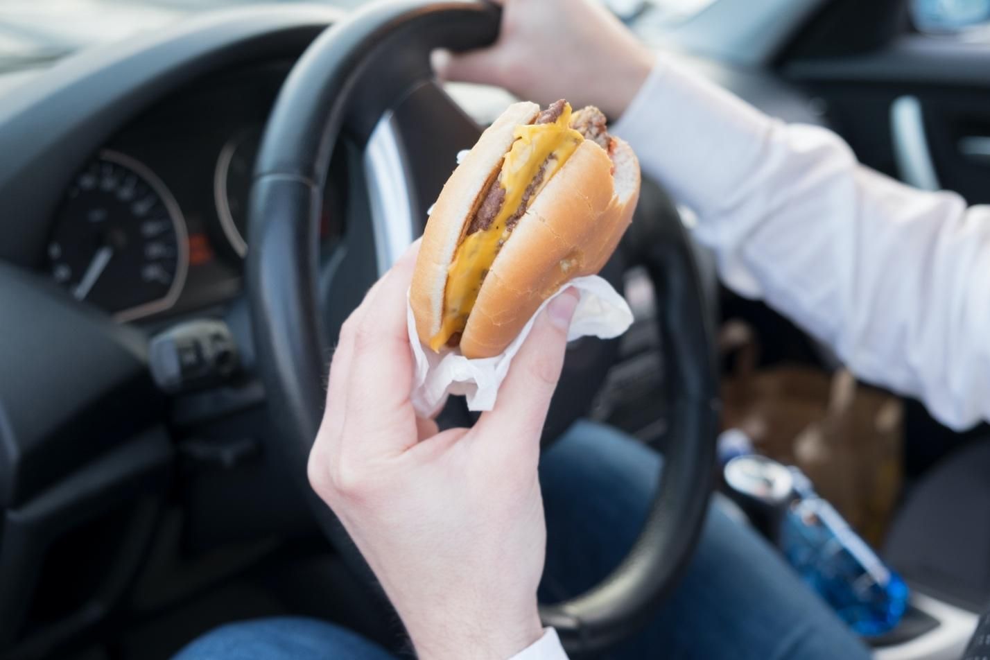 Eating a cheeseburger one-handed while driving.