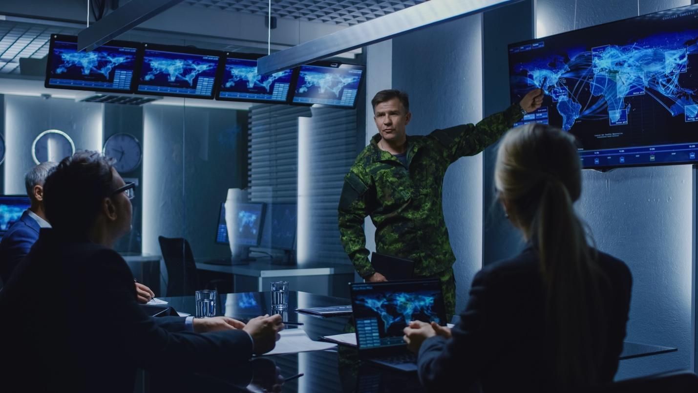 Concept image of a military officer in fatigues briefing a room of government officials.