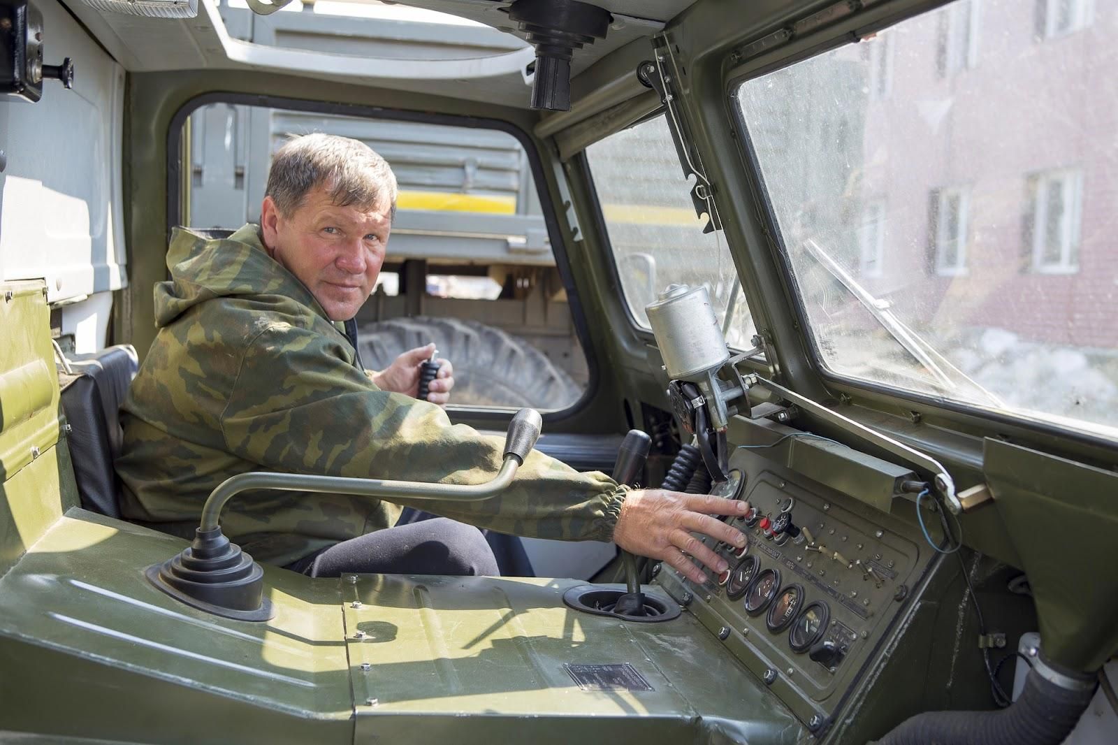 A military service member sits in the driver’s seat of a military vehicle. His job may be jeopardized by a suspension of driving privileges.