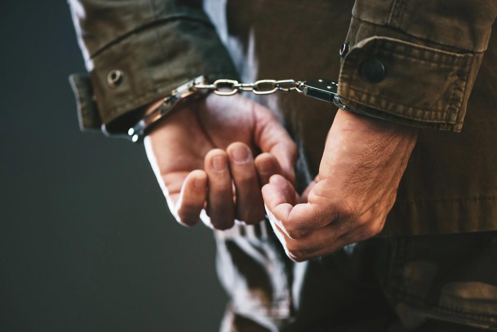 Soldier in the military potentially dealing with how convictions affect military service, shown in handcuffs.