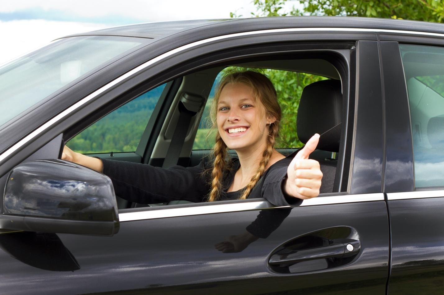 Young driver giving thumbs-up.