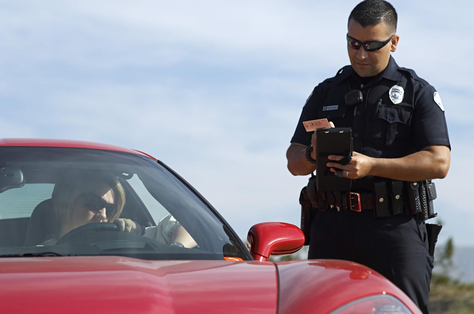 A police officer issues a motorist with a street racing ticket.