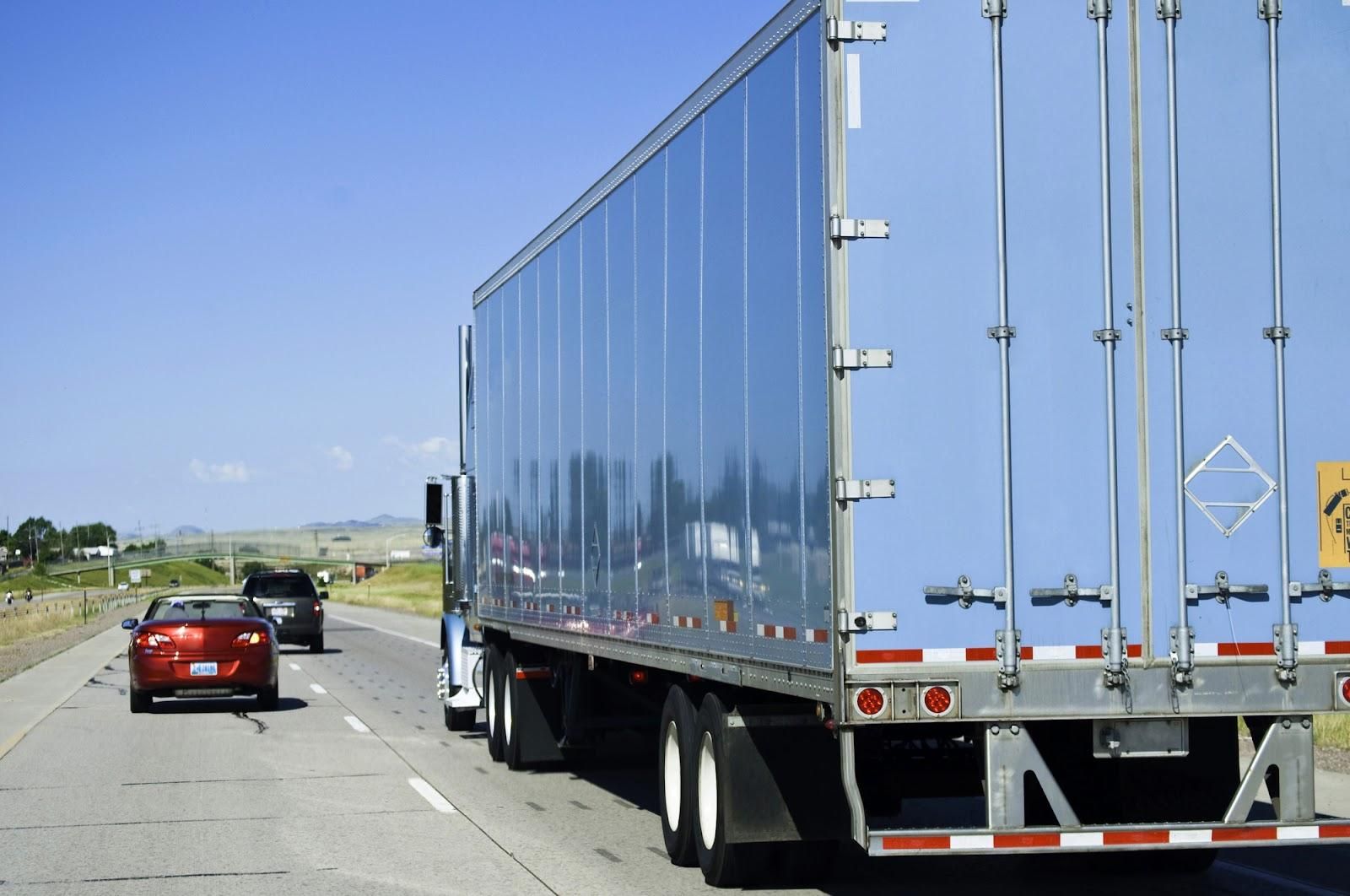 Passenger car overtaking semi-truck to the left on a divided highway which could result in an improper passing ticket.